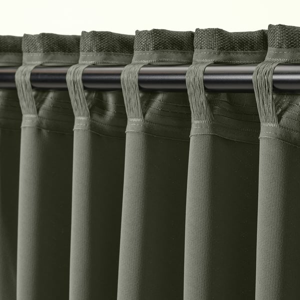 Close-up of curtains with heading tape and hooks, used for hanging on rods or gliders.