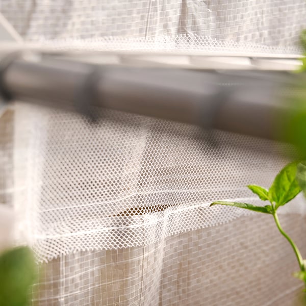 Aspern mini greenhouse in white with mesh, featuring 3 shelves, ventilation windows, and a roll-up door, ideal for small spaces.