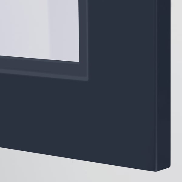 Modern dark blue cabinet close-up, smooth finish, inset glass panel.