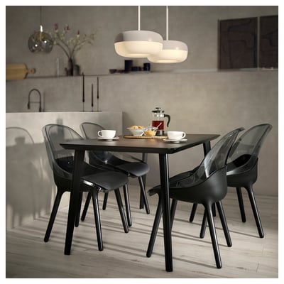 Modern dining set with dark chairs and wooden table, plus hanging lamp above.