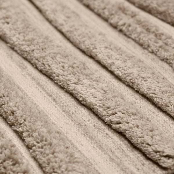 Folded wool rug close-up showcasing its soft, dense texture and natural, earthy tone.