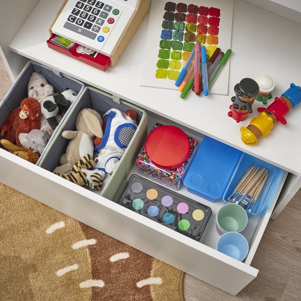 Organised kids storage drawer: stuffed animals, toys, art supplies, and painting tools neatly in sections.