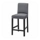 A grey upholstered bar stool, BERGMUND, with a cushioned seat and backrest, supported by black metal legs.