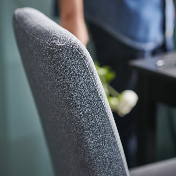 Grey fabric chair, close-up showing texture, part of seat.