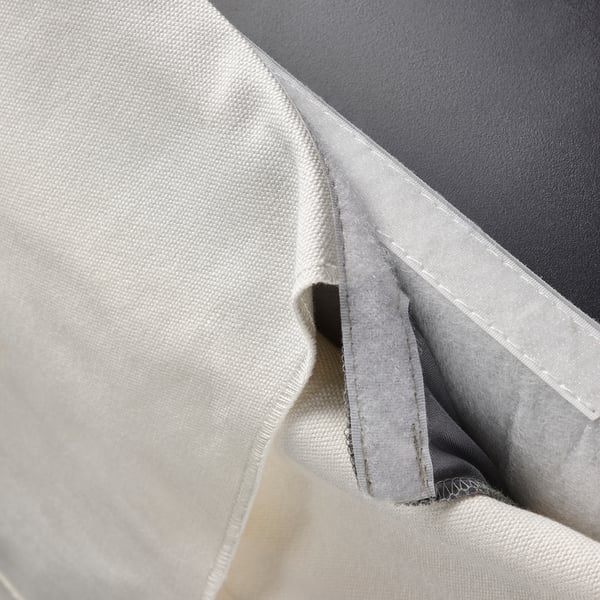 Close-up of BERGMUND chair cover: removable, machine-washable, 100% cotton. Shows covers sewing and fabric texture.