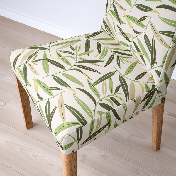 Stylish chair with leaf-patterned cover, wood legs, ergonomic seat.