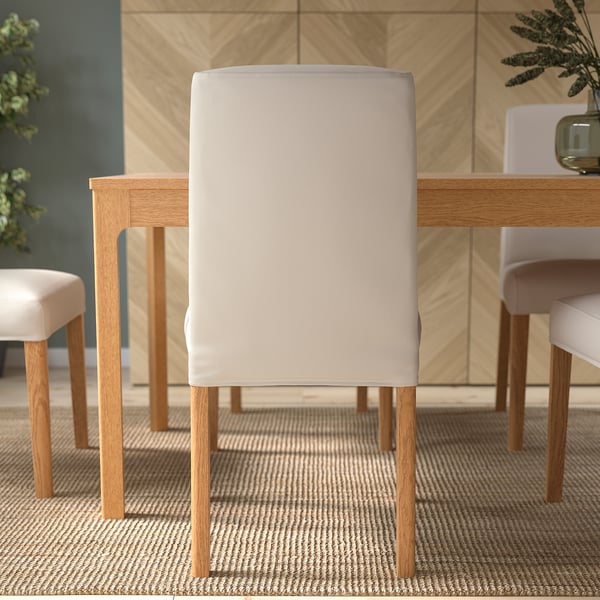 A modern chair with beige upholstery and wooden legs, providing comfort with lumbar support.