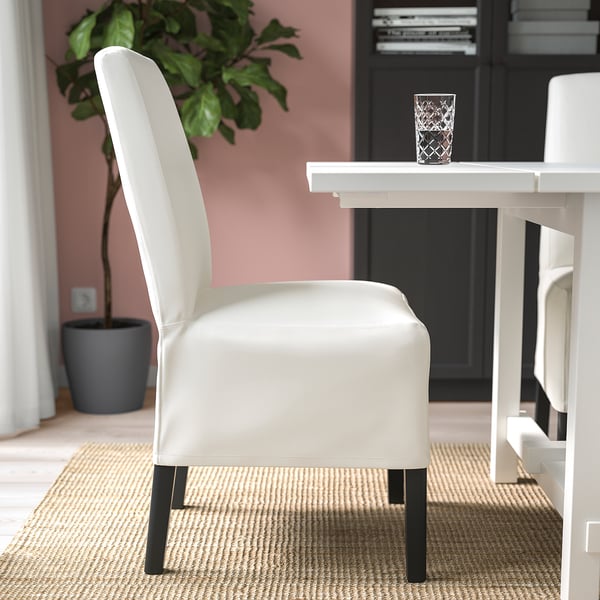 Chair with removable, washable cover and lumbar support sits near table with glass.