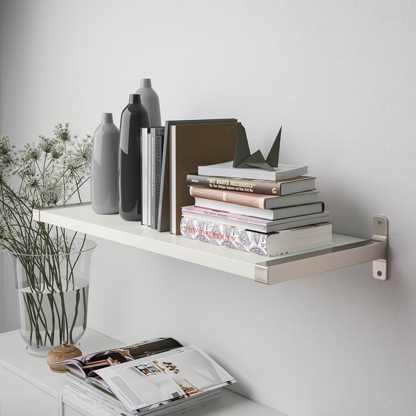 Wall-mounted shelf with books, vases, and plants. Holds up to 10 kg.