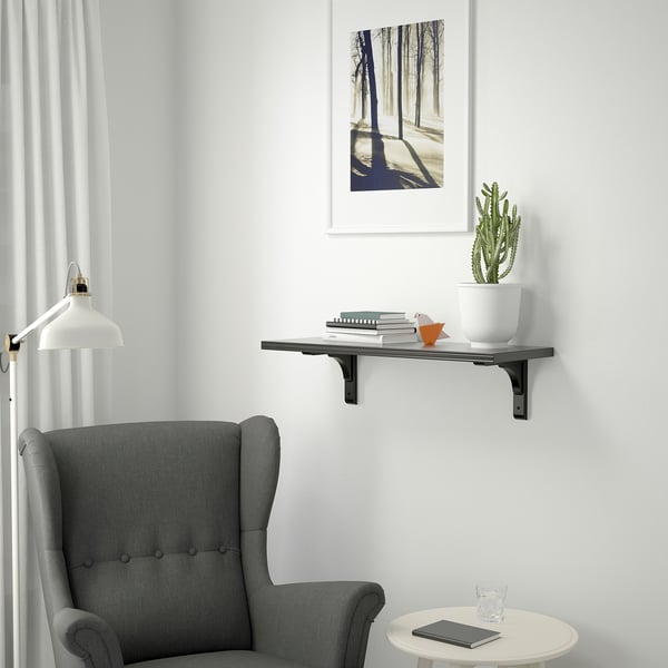 Modern living space with grey wingback chair and BERGSHULT shelf.