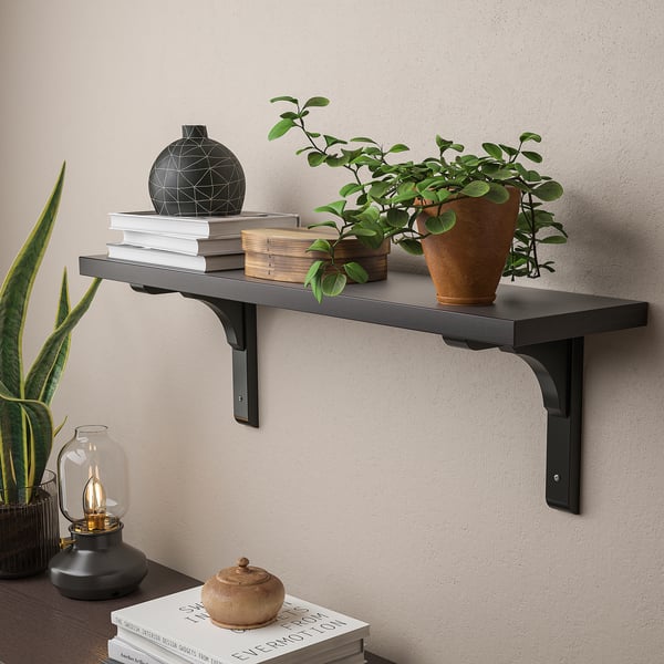 Wall-mounted shelf holding books, plants, and decor. Displays items neatly and utilises wall space.