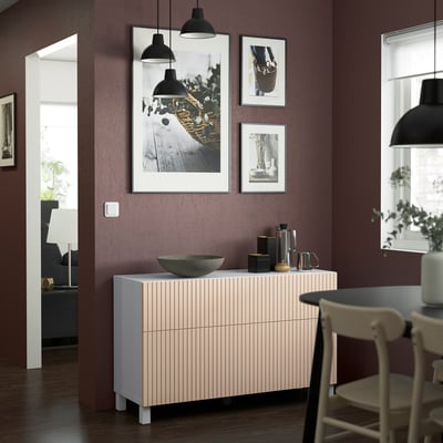 Modern room with BESTÅ beige sideboard, wooden texture, and storage. Three pictures above, drawers/shelves visible.