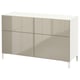 Modern white and beige cabinet with four sections: two drawers and two shelves, supported by sleek white legs, designed for stylish storage.