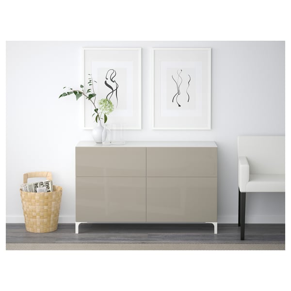 Modern living room setup with a BESTÅ sideboard featuring drawers and shelves, decorated with a vase, plants, and wall art.