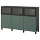 An ikea BESTÅ sideboard in green and dark colors. It has glass-topped doors and solid doors, with adjustable shelves inside.