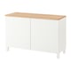 A BESTÅ white sideboard with a wooden top. It has two doors and stands on four square legs.
