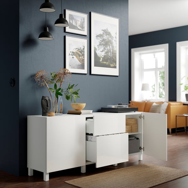 Modern living room with white BESTÅ sideboard against dark blue wall.