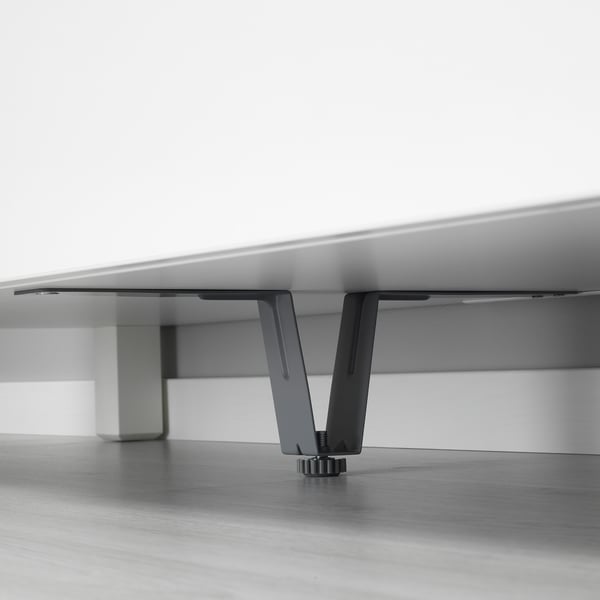 Black metal leg supports hidden under white furniture, enhancing stability.