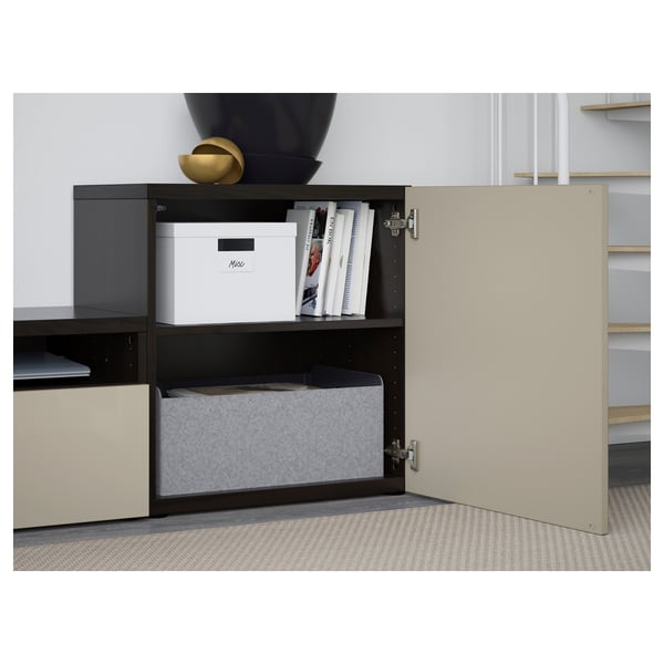 Open beige BESTÅ cabinet reveals storage boxes and organised items on shelves.