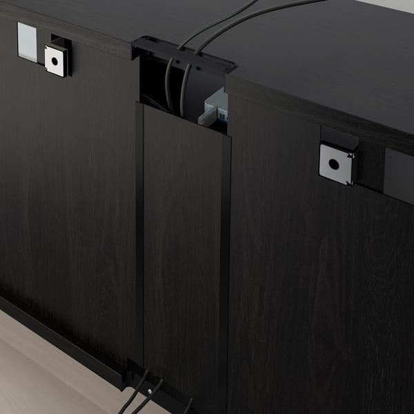 Black tv storage unit with adjustable shelves and cable management system, shown with organised cables and power outlet.