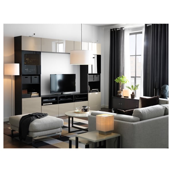 Modern living room with grey furniture, large tv, black curtains, and a lamp.