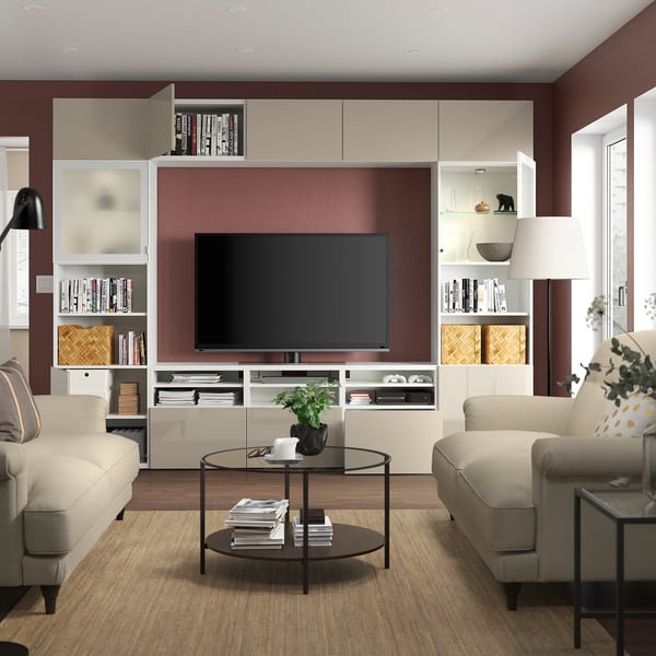 Modern living room with sofas, embroidered cushion, coffee table, tv, entertainment unit, and floor lamp.
