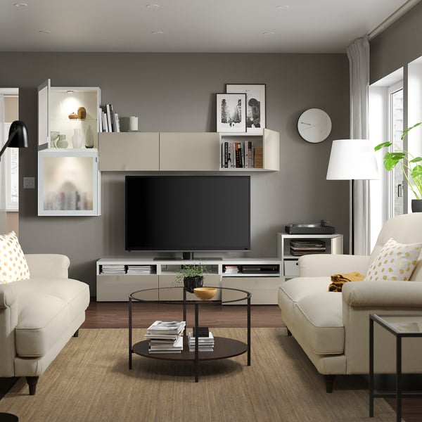 Modern living room with BESTÅ tv unit, white sofas, and glass coffee table.