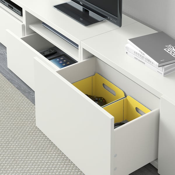 White tv stand with open drawers containing yellow dividers and electronic devices. Includes cable management and adjustable shelves.