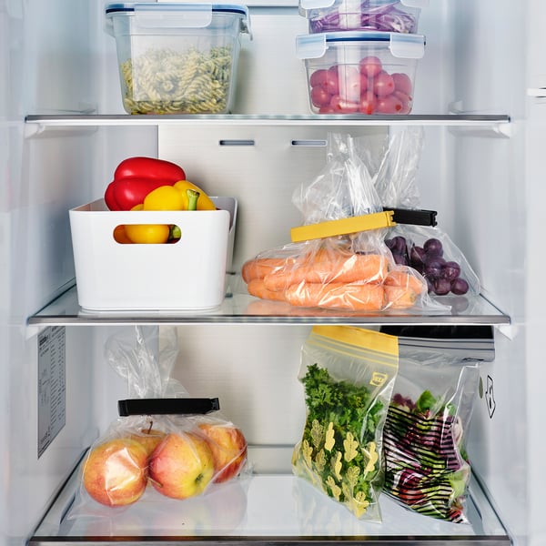 Refrigerator with organised fruits and veggies, including sealed bags using BEVARA sealing clips, keeping contents fresh.