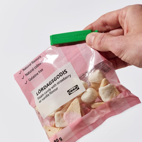 A hand holding a sealed candy bag with BEVARA clip, keeping contents fresh.