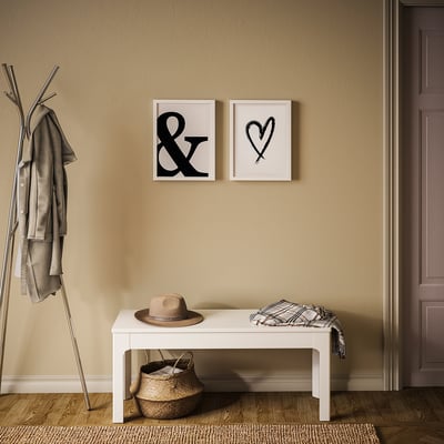 Cosy entry: beige wall, 2 black & white posters, bench with hat & blanket, coat rack, basket.