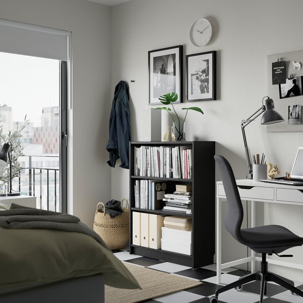 Modern home office: BILLY bookcase, desk, laptop, plant, city view.