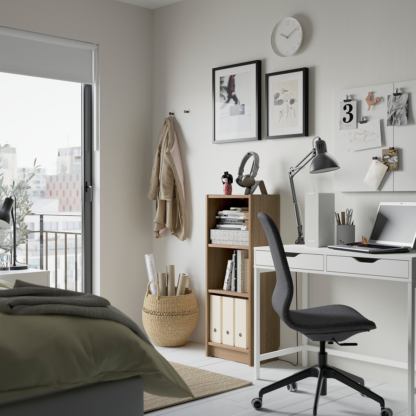 A compact home office with a white BILLY bookcase, a grey office chair, and a desk with a laptop and plants.