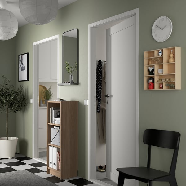 Modern living room with BILLY bookcase, black chair, clock, and decor.
