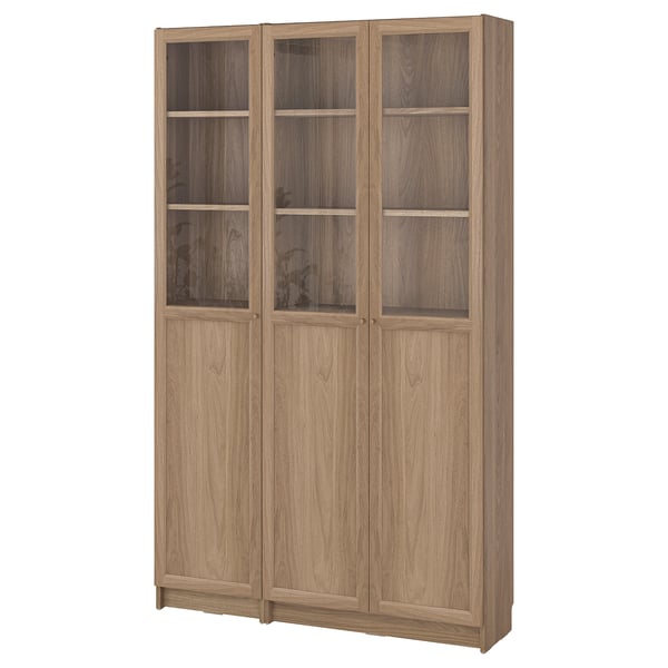Wooden BILLY bookcase in beige with glass doors and shelves. Tall, rectangular, light brown.
