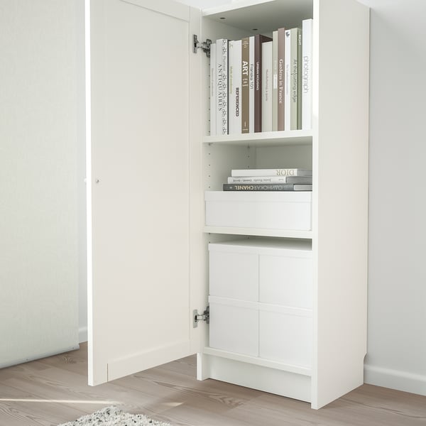 White BILLY bookcase with panel doors. Top shelves hold books, bottom has closed storage.
