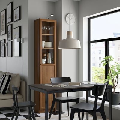 Cosy dining space with BILLY bookcase, black chairs, table, and decor.