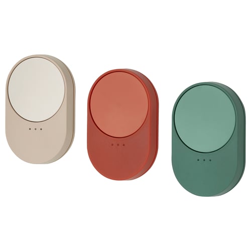 Three oval-shaped remotes: beige, rust red, and teal green, made of plastic for controlling smart home devices.