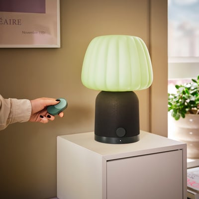 Three oval-shaped remotes: beige, rust red, and teal green, made of plastic for controlling smart home devices.