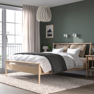 BJÖRKSNÄS bed, wooden headboard, dark green wall, pendant light, sheer curtains, rug, bedside table, cosy queen bed.