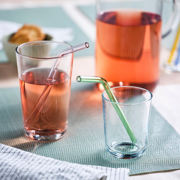 Two glasses with coloured straws on a placemat, eco-friendly reusable straws.