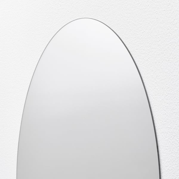 Sleek, wall-mounted mirror with polished edges, reflecting light softly, enhancing room decor.