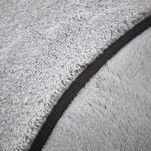 Dual-textured, grey cushion close-up. Soft, fluffy side and smooth, woven side evident, showcasing quality blend.