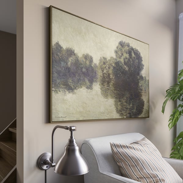 Monets large wall painting of trees, above couch with pillow, beside wall light.