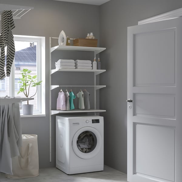 Organised laundry room with BOAXEL storage, towels, clothes, washing machine, and plant.