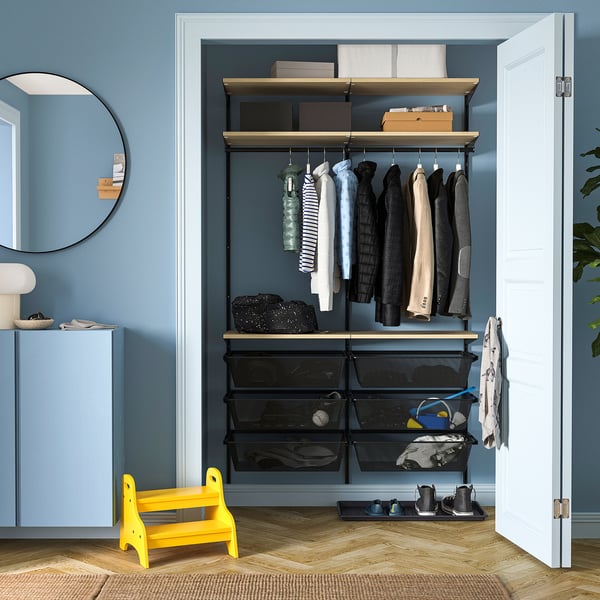 BOAXEL closet with black baskets, wooden shelves, stool, blue wall, white door.