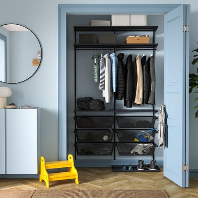 Yellow stool, black BOAXEL closet, neat clothes, blue walls.
