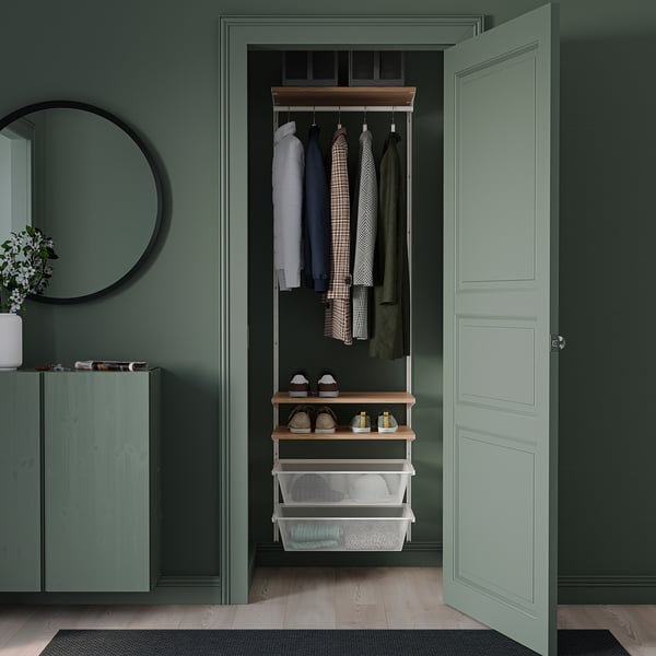 Small closet with clothes, shelves, green walls, light floors, mirror, & cabinet.