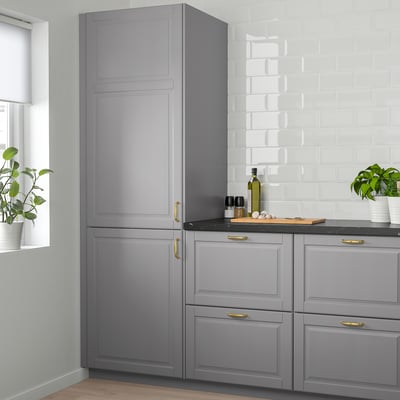 Modern kitchen with grey BODBYN cabinets, gold handles, and black countertop.