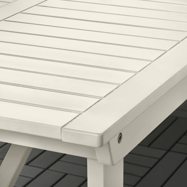 White outdoor table with slatted design, sturdy acacia wood, and protective paint finish.